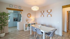 A modern kitchen with a built-in oven and a dining area with a table and chairs.