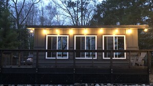 Moderni talo, jossa on terassi, suuret ikkunat ja kivinen perustus.