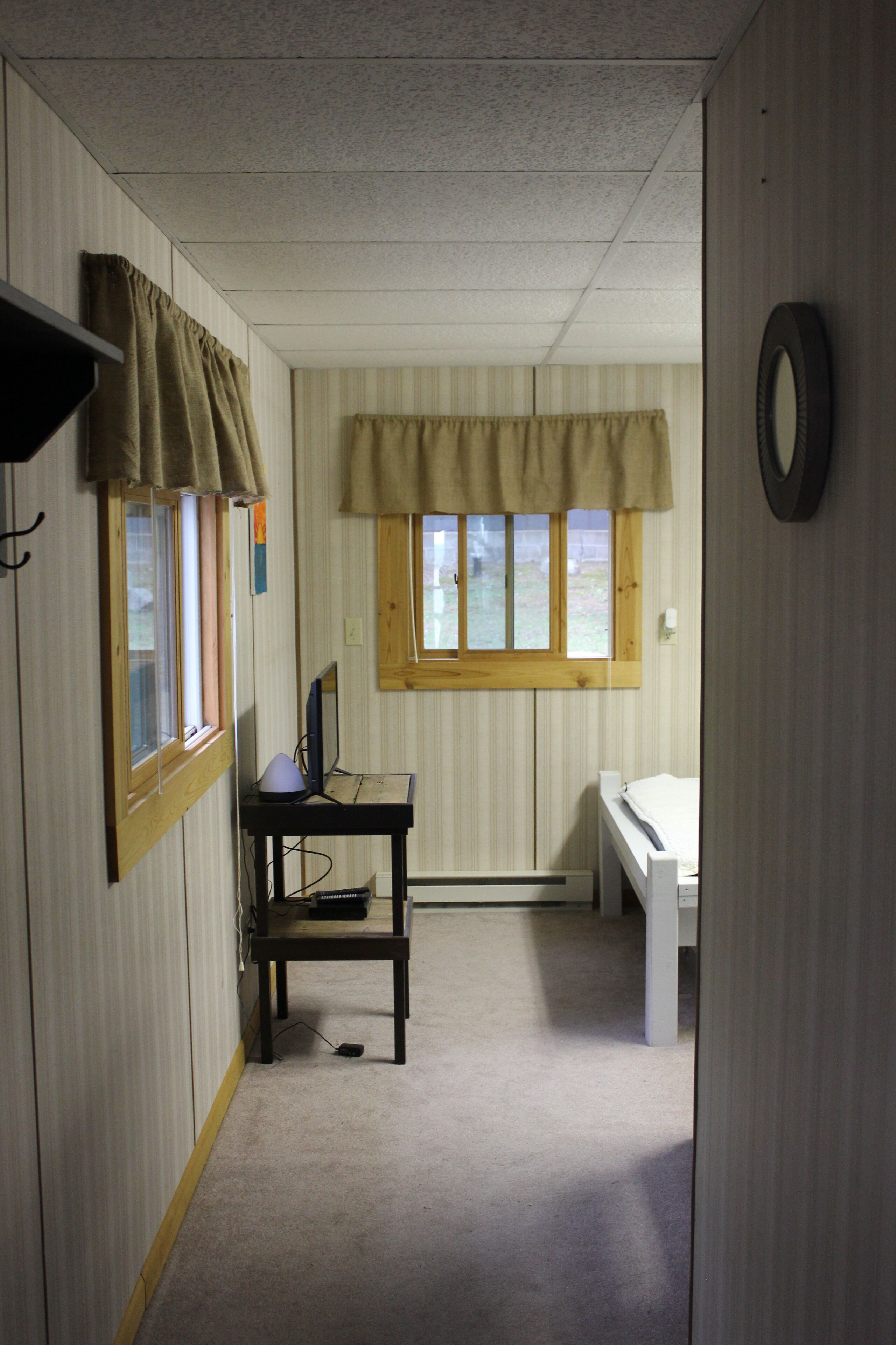 Una habitación con escritorio, silla y cama.