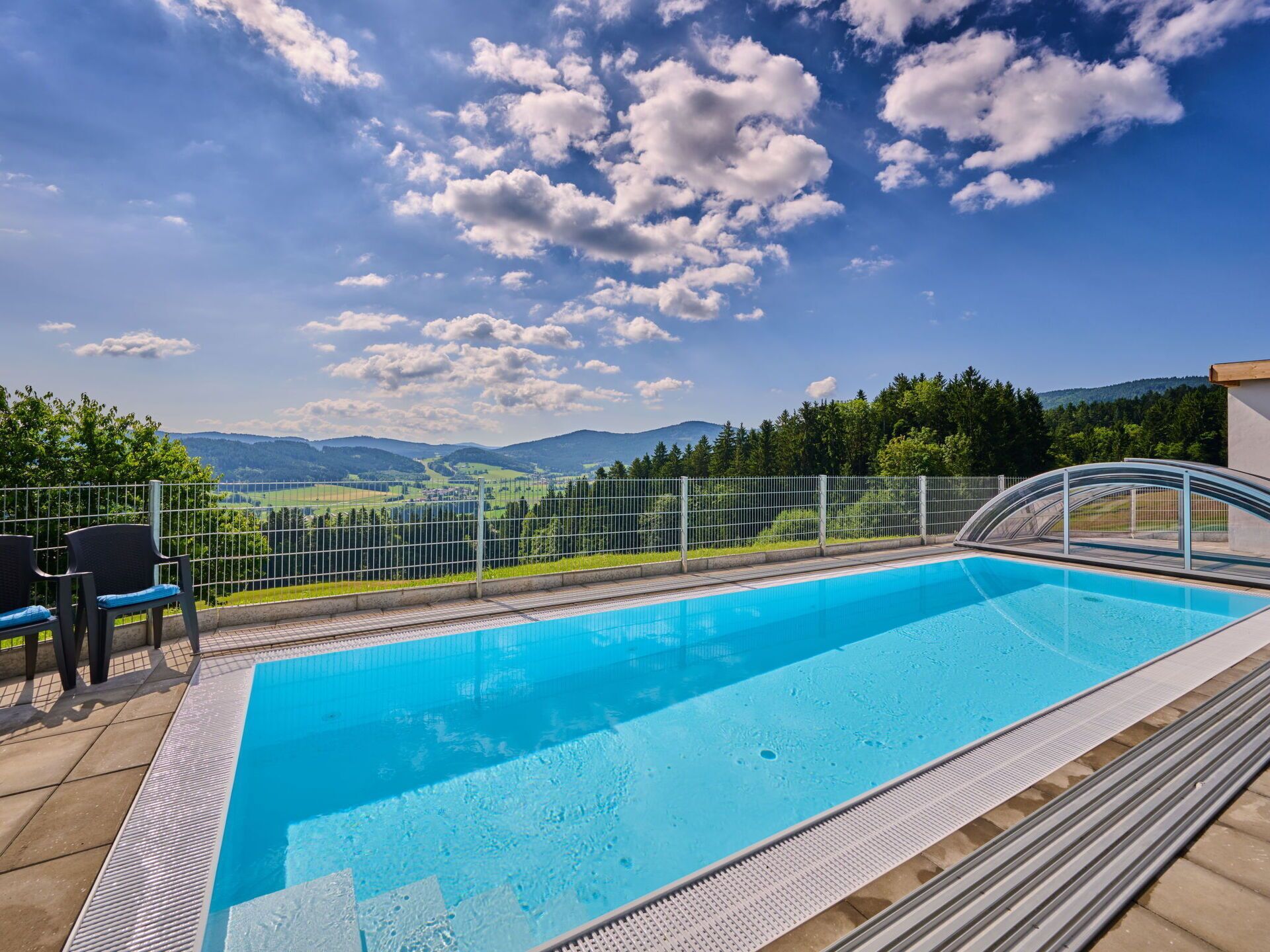 Una piscina con vista libera sul paesaggio circostante, tra cui montagne e alberi.