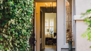 An arched entrance with a doormat, a large vase, and a dining area visible through the doorway. - Golf Course Luxury with Pool, Spa, Casita & Mountain Views! (Indio)