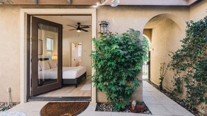A bedroom with a bed, a ceiling fan, and a view of the interior through a glass door. - Golf Course Luxury with Pool, Spa, Casita & Mountain Views! (Indio)