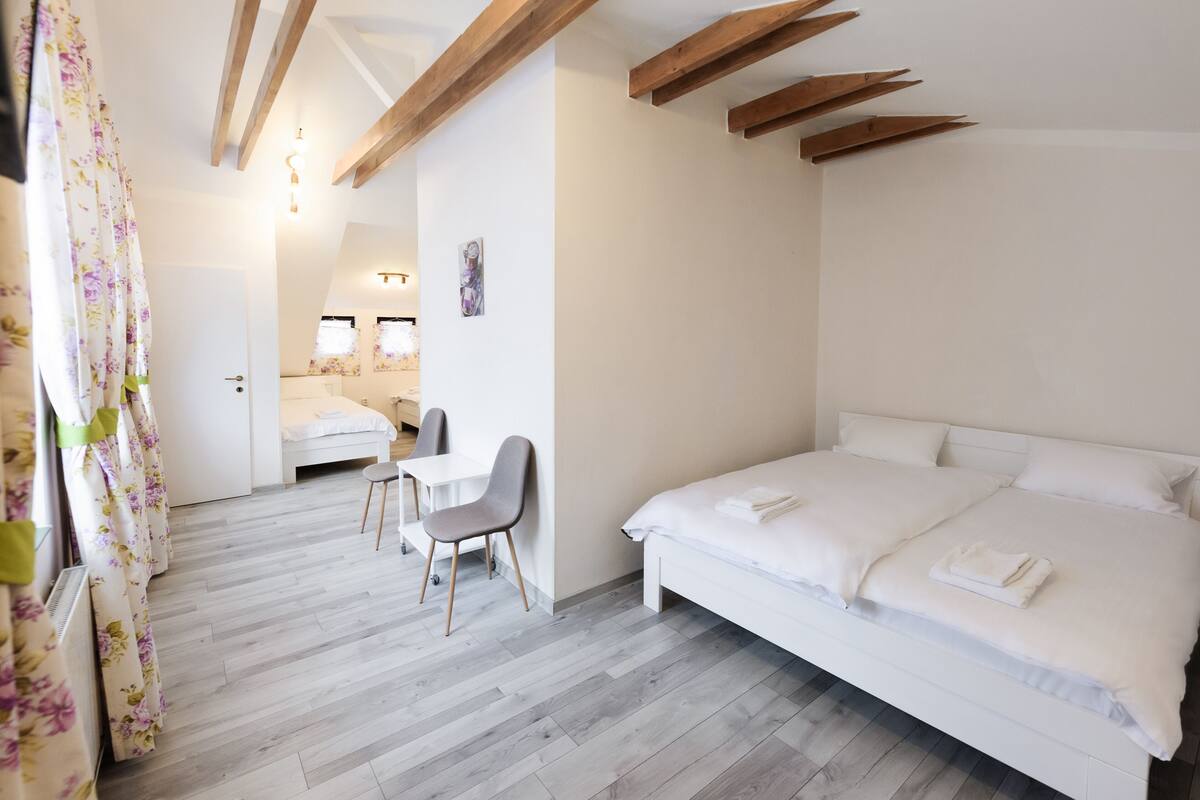 A bedroom with a bed, a desk, and a chair.