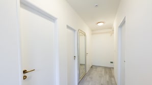 A narrow hallway with white walls and wooden flooring. - Penzion La Route (Prague)