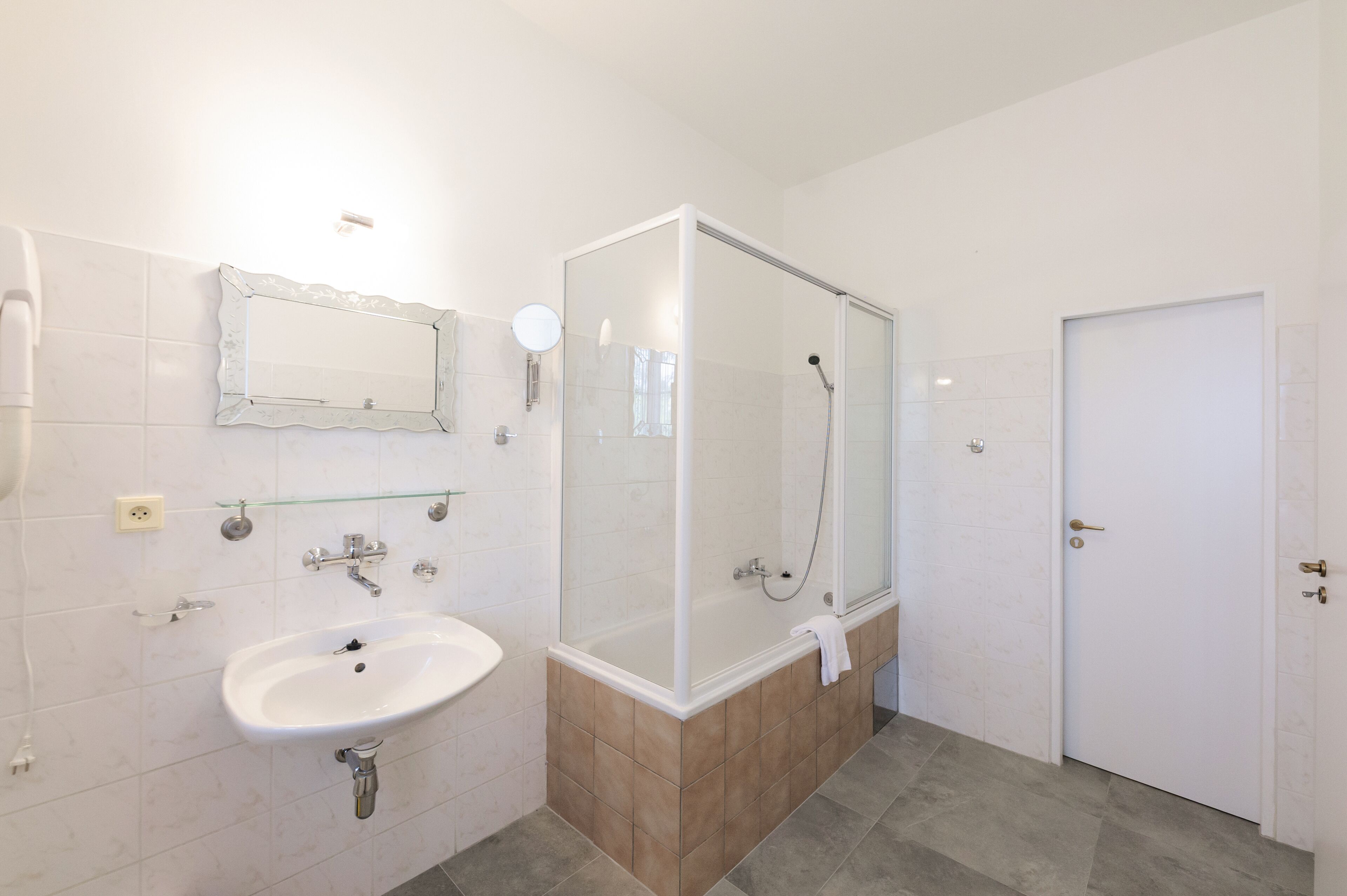 Un baño con lavabo, espejo, ducha e inodoro.