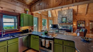 A spacious log cabin interior with a kitchen, dining area, and living room. - 1 Sublime View - Beautiful views, hot tub, great amenities, close to Boone! (Deep Gap)