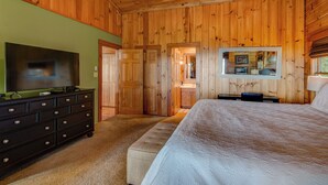 A wooden-paneled bedroom with a bed, dresser, and television. - 1 Sublime View - Beautiful views, hot tub, great amenities, close to Boone! (Deep Gap)