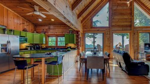 A spacious cabin with a large kitchen, dining area, and a view of the outdoors. - 1 Sublime View - Beautiful views, hot tub, great amenities, close to Boone! (Deep Gap)