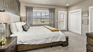 A bedroom with a large bed, a bedside table with a lamp, a window with curtains, and a door with a coat closet. - Serenity-Themed, Fastest WiFi, 2 King Beds Home (Medford)