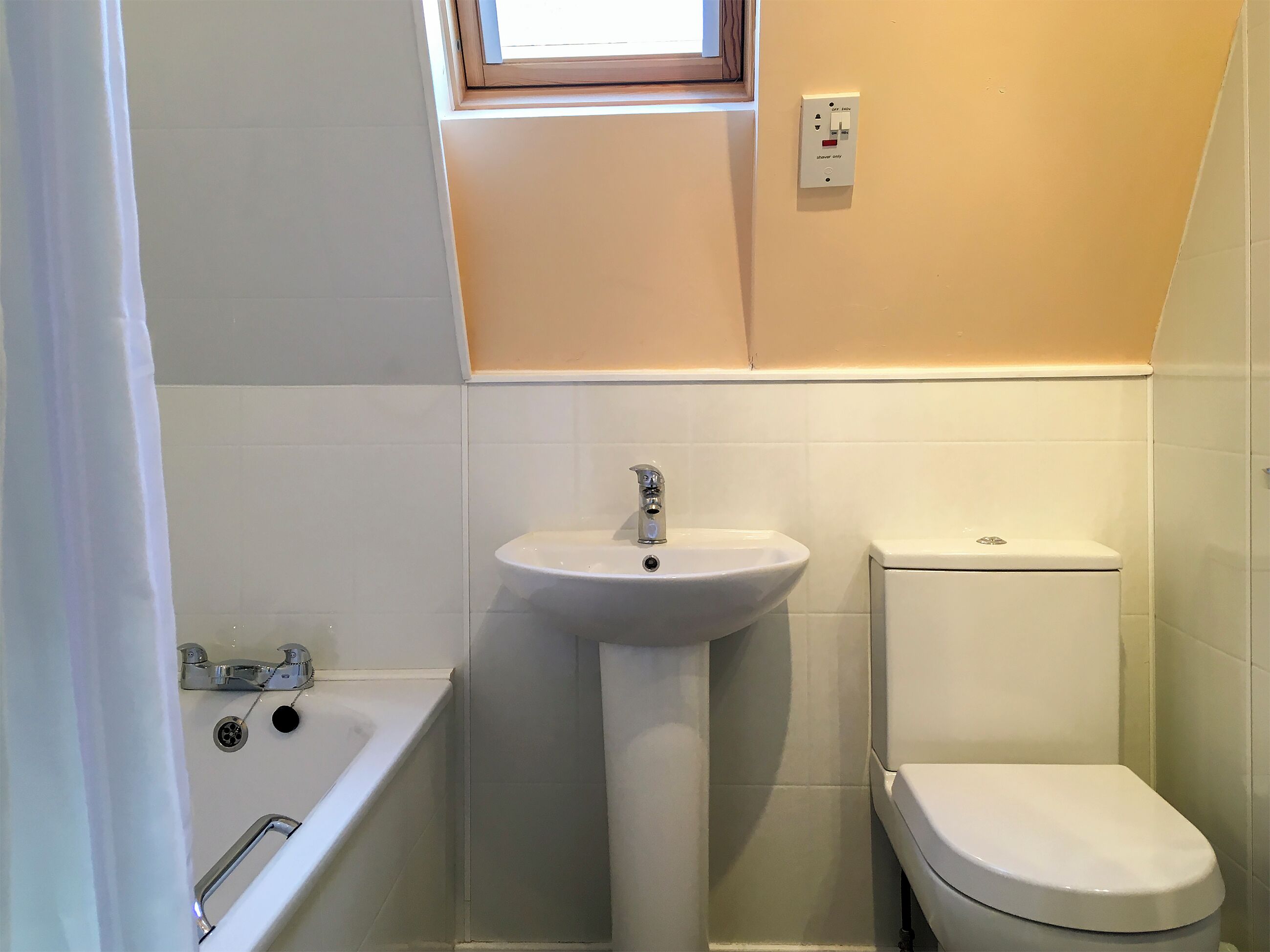 A bathroom with a pedestal sink, a toilet, and a bathtub.