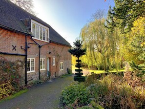A brick house with a paved pathway leading to a small garden area.