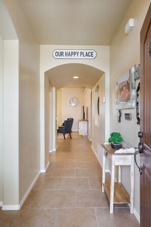 Enter a welcoming space with a dining area featuring a table, chair, and potted plant.