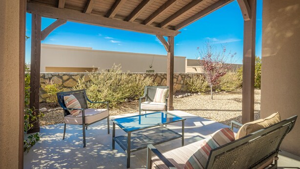 An outdoor patio with a glass table, two chairs, and a sofa. - *Tranquil Living in the City* (Las Cruces)