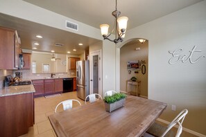 Enjoy meals in the kitchen with a sink and stainless steel refrigerator, surrounded by wooden cabinets and a granite countertop.
