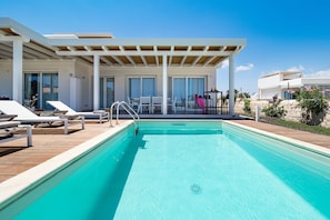 A modern pool area with lounge chairs and a covered patio.