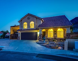 A two-story house with a garage, a covered porch, and a well-lit front yard. - Upscale 4 BR Home with RV parking (Henderson)