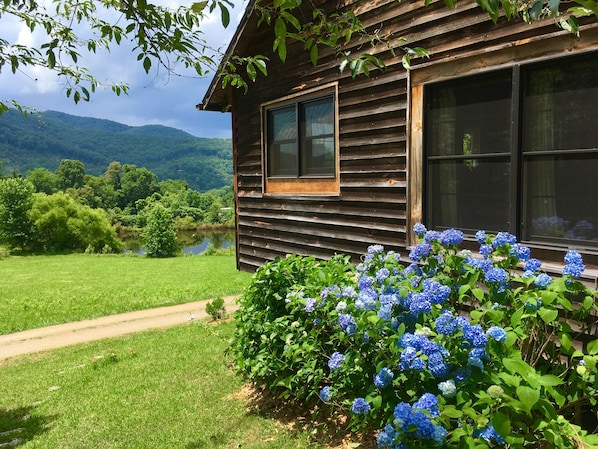 A wooden cabin with a view of a lake and mountains.