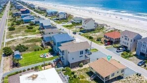 A coastal residential area with houses, a beach, and a road. - Mountains to Sea | Pet Friendly + Steps to Beach! (Holly Ridge)