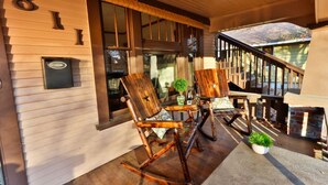 A wooden porch with two rocking chairs, a mailbox, and a brick fireplace. - Craftsman on Whitman · Updated Craftsman on Whitman, Close to Everything! (Walla Walla)