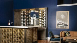 A bar area with a wine rack, a sofa, and a painting on the wall. - Craftsman on Whitman · Updated Craftsman on Whitman, Close to Everything! (Walla Walla)