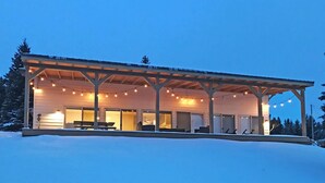 A covered outdoor area with string lights, benches, and a snow-covered ground. - Georgetown Lake Retreat (Anaconda)