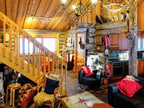 A log cabin interior with a wooden staircase, a dining area, and a kitchen. - Teeritaivas by Interhome (Inari)