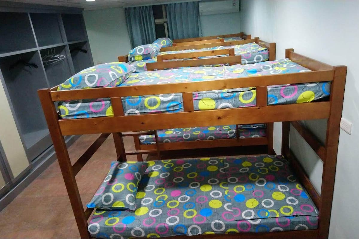 Una cama litera con ropa de cama de diseño circular y colores vivos.