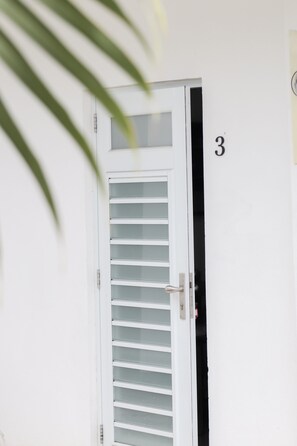 A white door with a frosted glass panel and a number '3' on the wall.