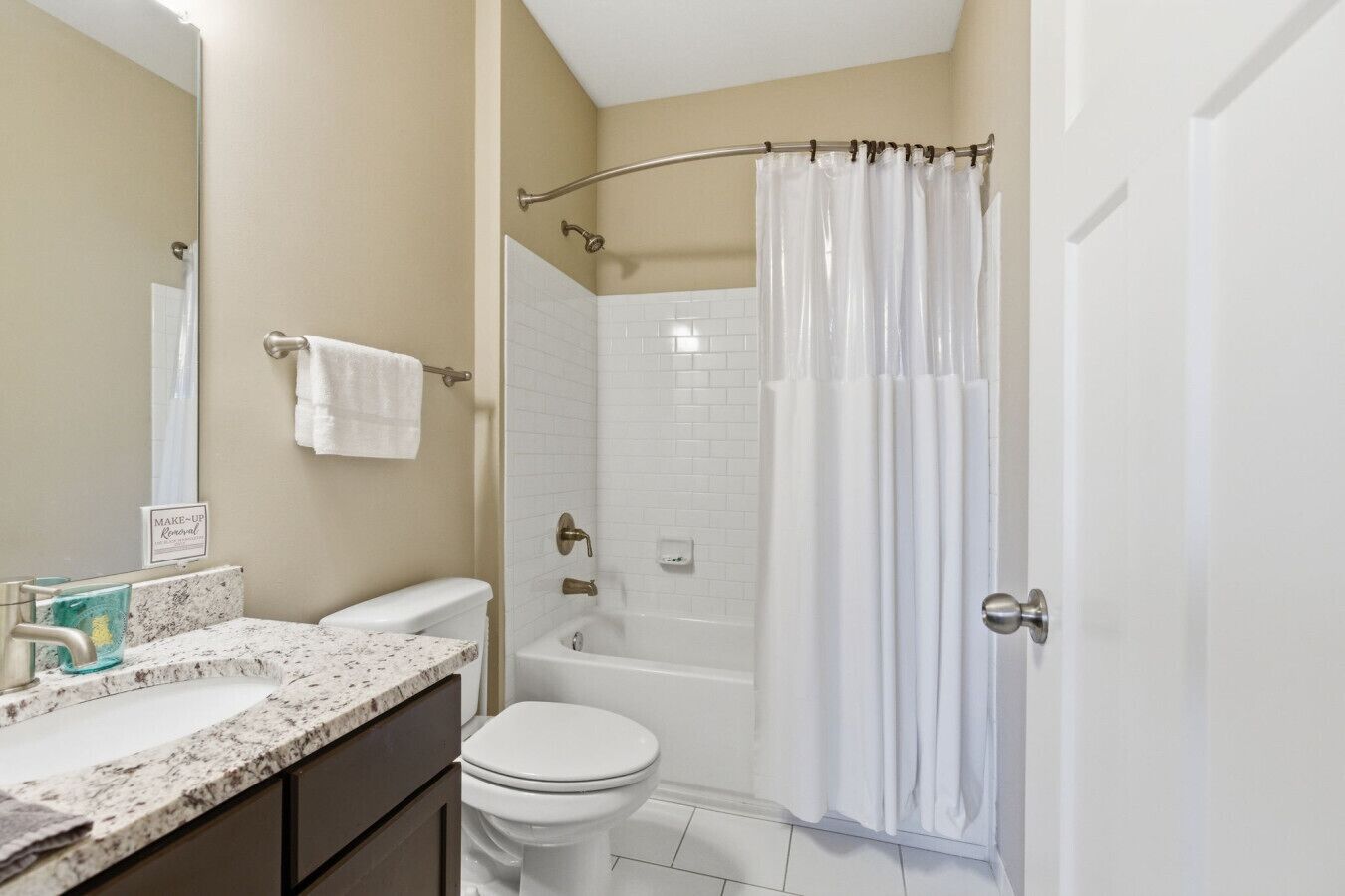 Un bagno con servizi igienici, lavandino, vasca e tenda da doccia.