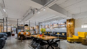 A modern interior with a wooden dining table, black chairs, a sofa, and a yellow armchair. - Hexi Boutique Hotel Chengdu (Chengdu)