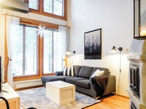 A living room with a grey sofa, a white coffee table, and a fireplace.