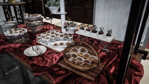 Una mesa de buffet con diversos alimentos y una copa de vino.