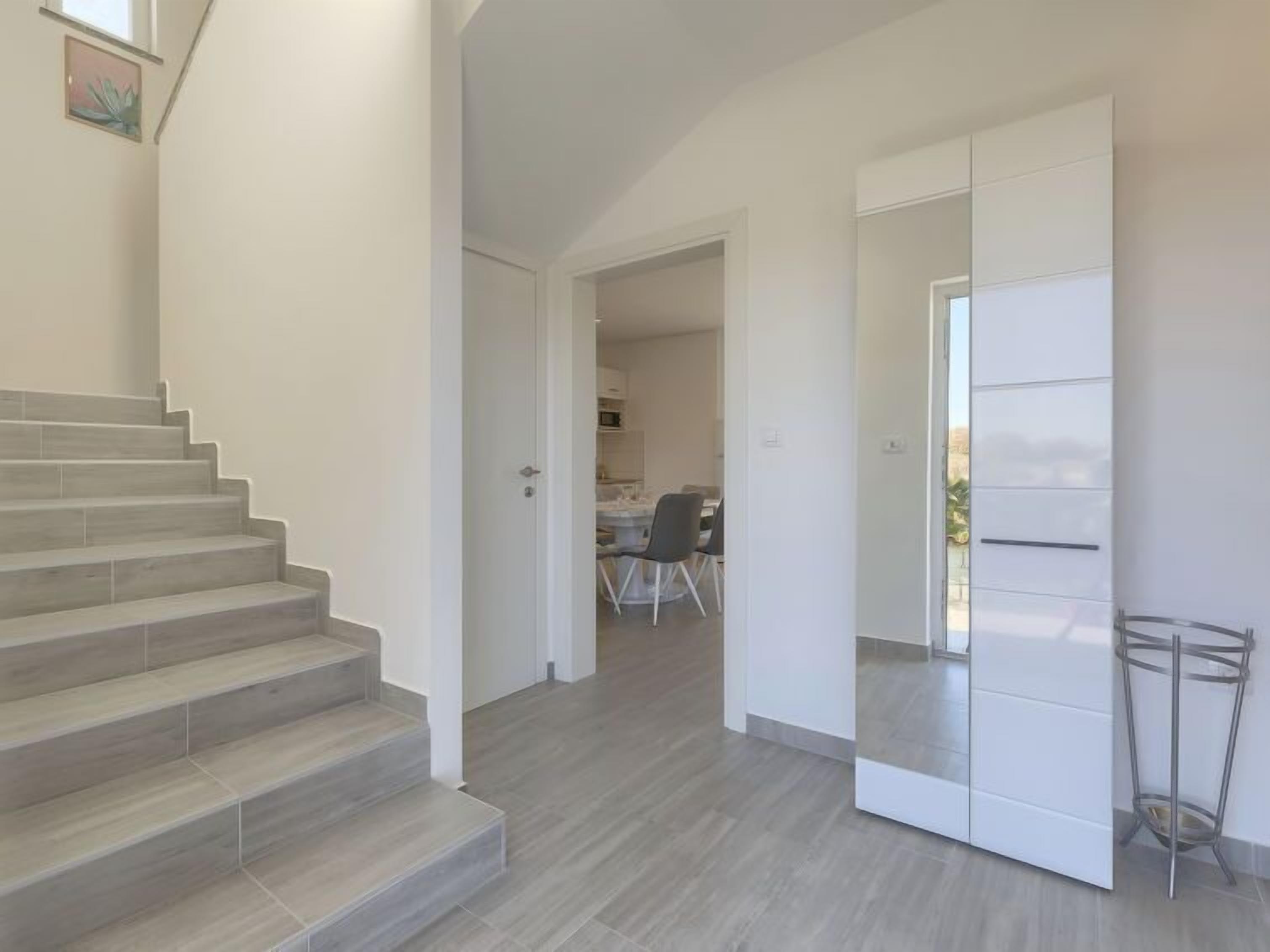 Un interior moderno con una escalera que lleva a un comedor.