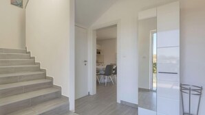 Un interior moderno con una escalera que lleva a un comedor.