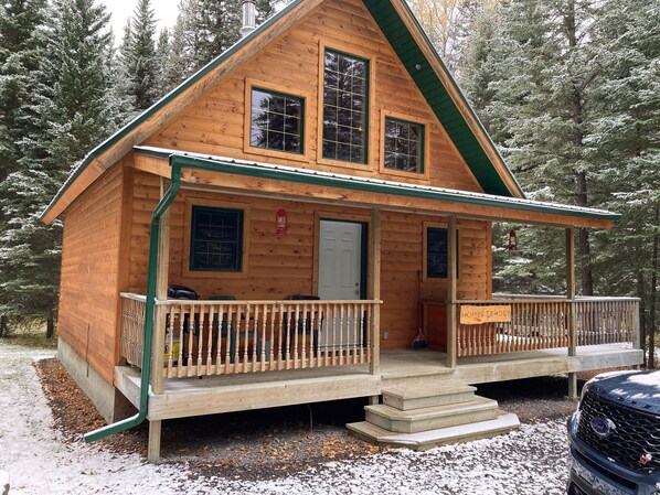 A wooden cabin with a porch, a front door, and a sign that reads "HOMESTEADER."