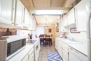 Efficient kitchen with appliances, sink, and ample storage.