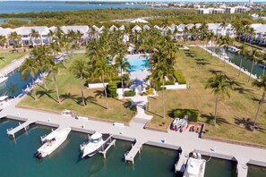 A resort with multiple villas, a central pool, and a marina with boats.