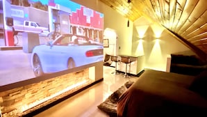 A room with a TV displaying a car, a small bar area, and a wooden ceiling. - Loft + private terrace with jacuzzi, fireplaces, cinema, panoramic view (Bogotá)