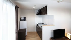 A compact kitchen with a built-in stove, a microwave, and a sink.