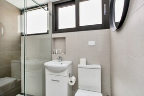 A modern bathroom with a glass shower enclosure, a white sink, and a toilet. - One bedroom  in Australia, Surry Hills (Surry Hills)