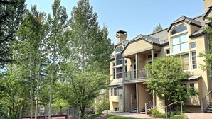 A multi-story building with a balcony, a staircase, and a gated entrance.
