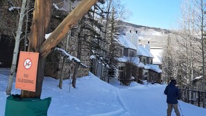 A wooden signpost with a 'Highlands Skiway' sign and a 'NO SLEDDING' sign.