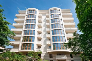 A modern multi-story building with balconies and large windows.