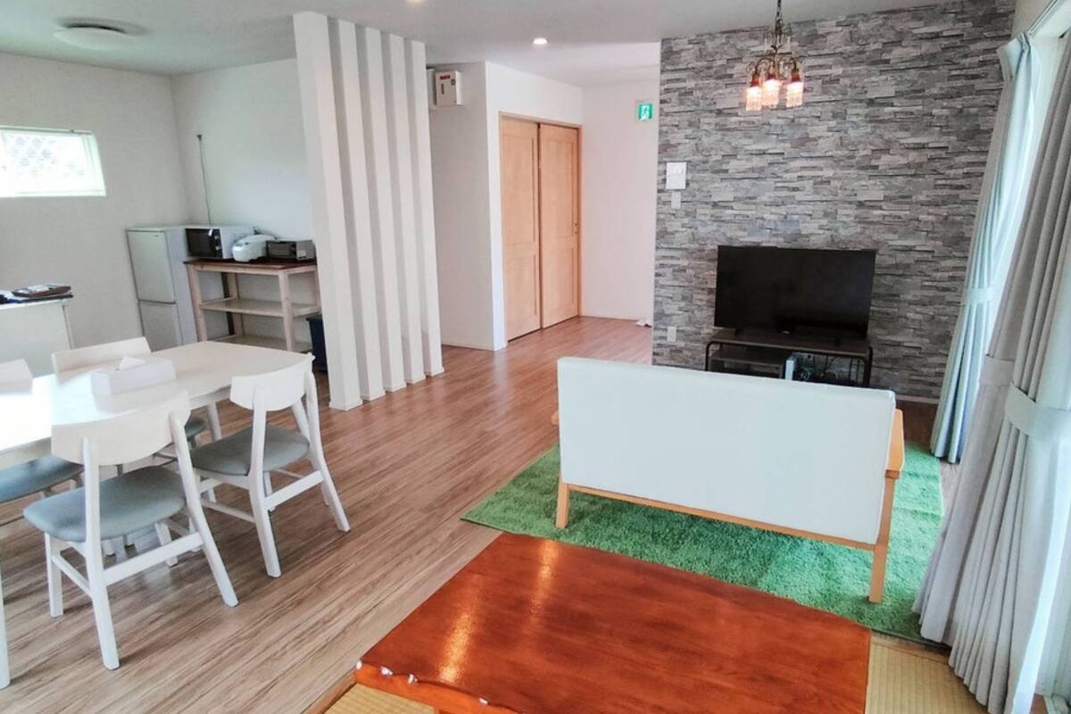 Uma sala de estar moderna com área de jantar, lareira e televisão.
