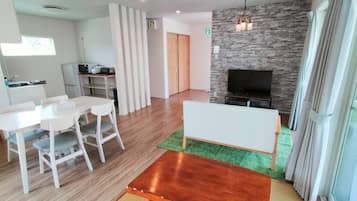 Una sala de estar moderna con comedor, chimenea y televisor.