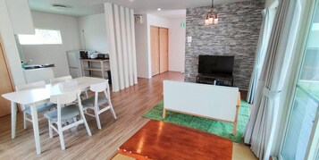 Una sala de estar moderna con comedor, chimenea y televisor.