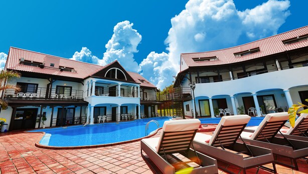 A swimming pool with lounge chairs, a covered area, and a building with a red-tiled roof. - Private Villa Espacio Onna (Onna)