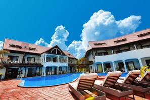 A swimming pool with lounge chairs, a covered area, and a building with a red-tiled roof. - Private Villa Espacio Onna (Onna)