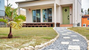 A pathway leading to a building with large windows and a green door. - Private Villa Espacio Onna (Onna)