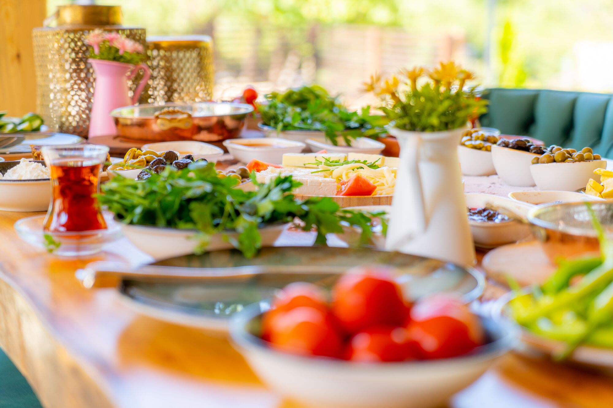 A table with various dishes and a glass of tea, suggesting a dining setting.